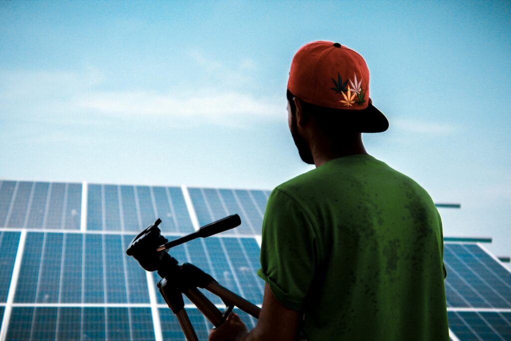 pexels-photo-1254997-1254997 A person in a cap films a solar panel installation, promoting sustainable energy solutions.